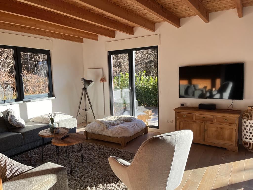Chalet Presseggersee komfortables Wohnzimmer mit Ecksofa, Esstisch für 10 Personen, Smart-TV und Holzofen